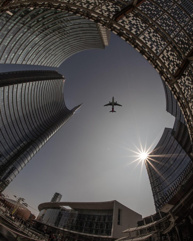plane, city, architecture, sky, airplane, flight, travel, sun, urban, buildings, tourism, outdoors, transportation, cityscape, skyline, tower, skyscrapers, lookup, nature, aircraft